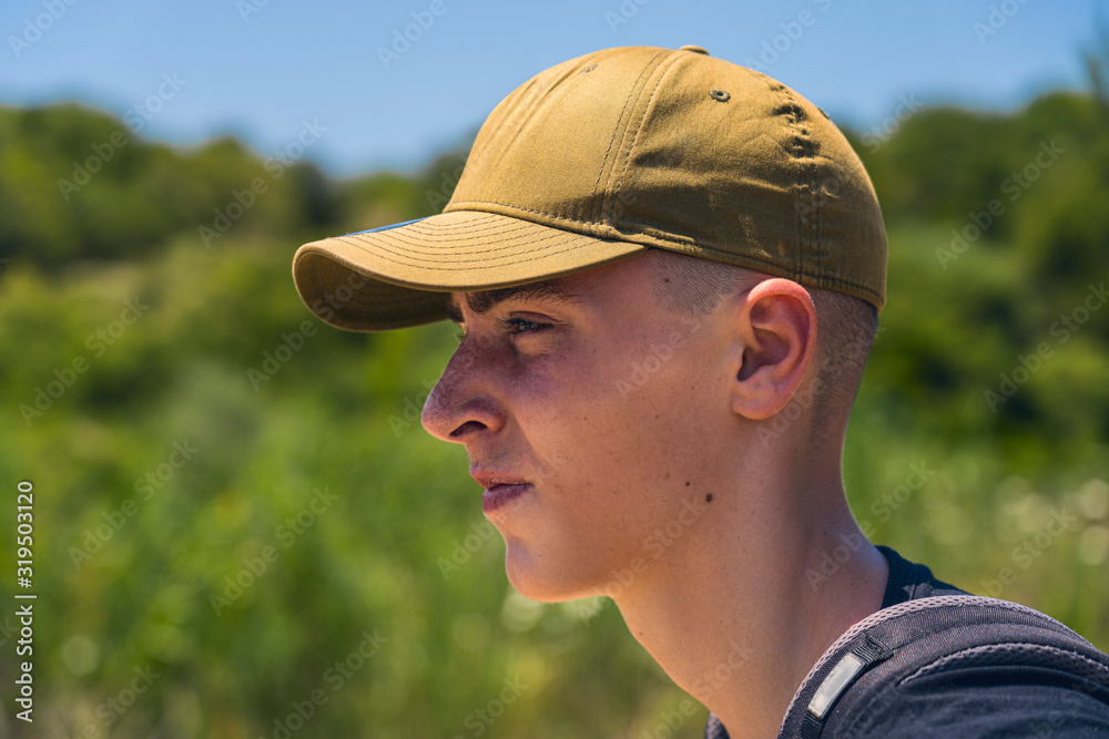 portrait of a young man with base cap in profile