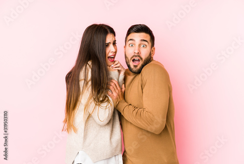 Young caucasian couple isolated scared and afraid.