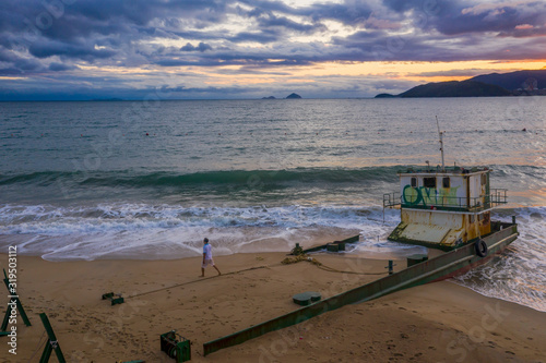 Nha Trang, Vietnam sunrise featuring south China Sea, East Sea, distant islands and a ship wreck in the foreground beach