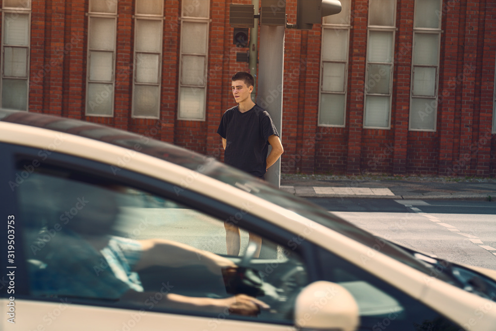 portrait of a lonely young man where a car drives through the picture portrait of a lonely young man where a car drives through the picture