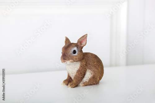 Ceramic figurine of rabbit  Isolated on white background. Close-up of brown statuette of an Easter bunny. Porcelain bunnie. Easter decoration - ceramic easter rabbit on white background. Ceramic bunny