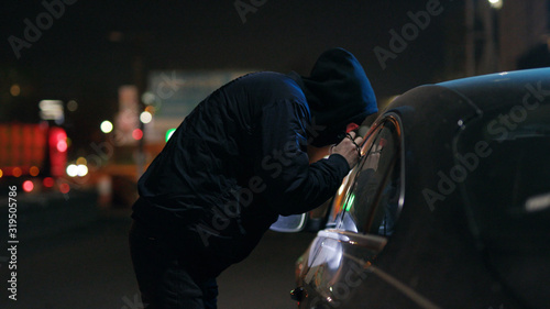 Canvas Print Close up robber man checking shines a flashlight in a car stealing at night crim
