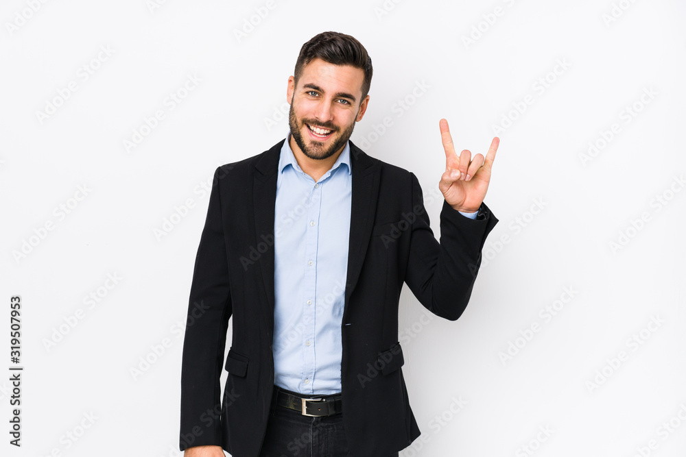 Young caucasian business man against a white background isolated showing a horns gesture as a revolution concept. Young caucasian business man against a white background isolated showing a horns gesture as a revolution concept.