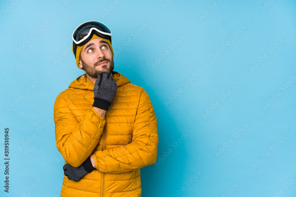 Young skier caucasian man isolated relaxed thinking about something looking at a copy space. Young skier caucasian man isolated relaxed thinking about something looking at a copy space.