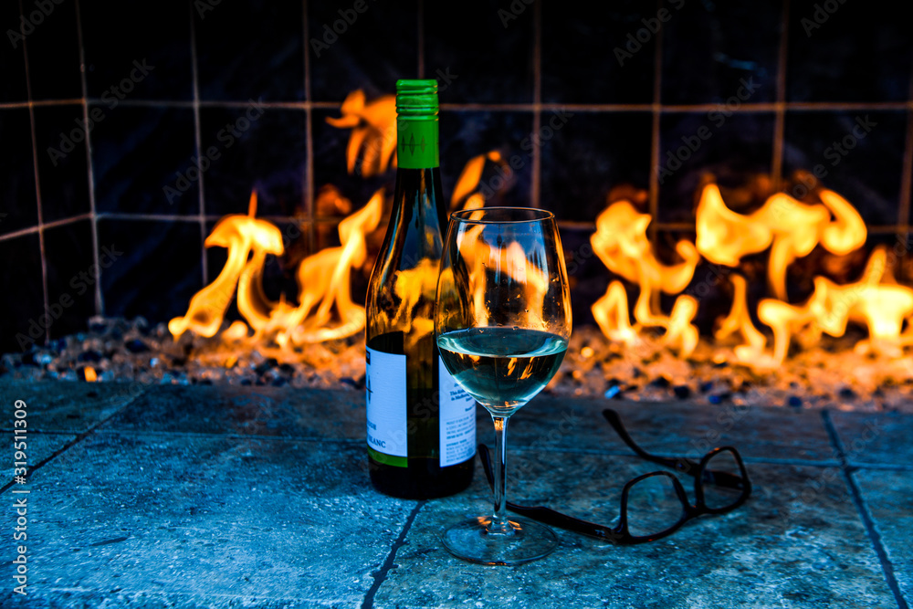 Obraz premium wine bottle and glass on a outdoor fireplace.