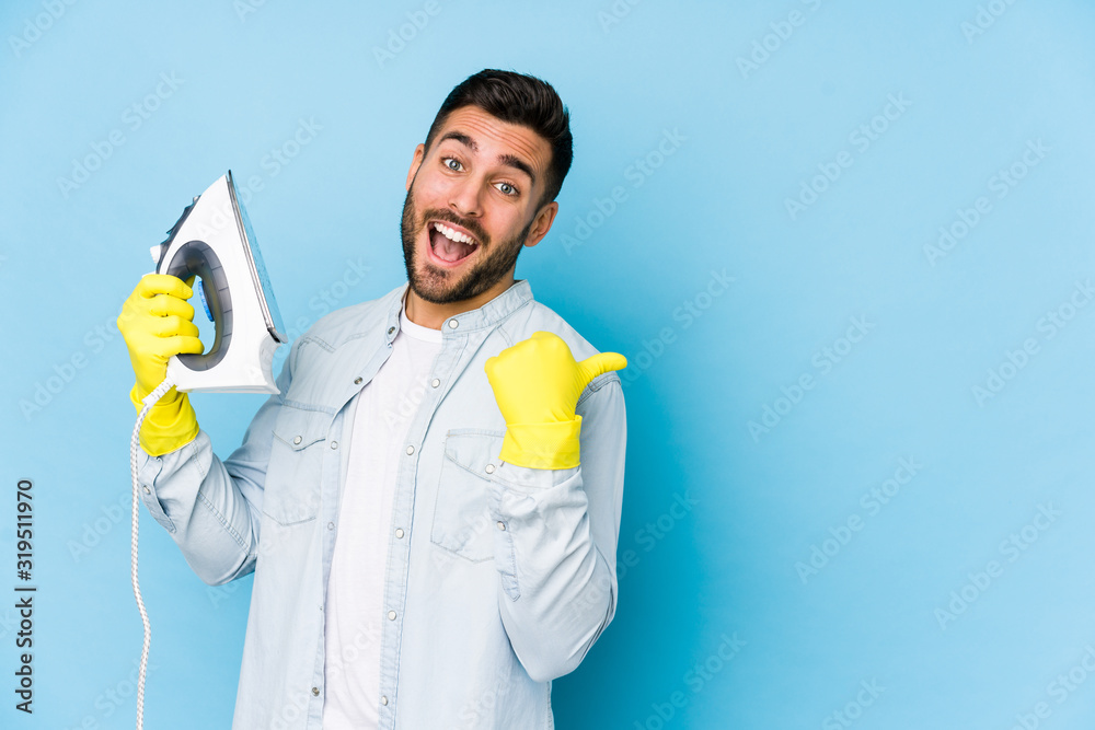 Φωτογραφία Portrait of young man ironing isolated points with thumb finger away, laughing and carefree