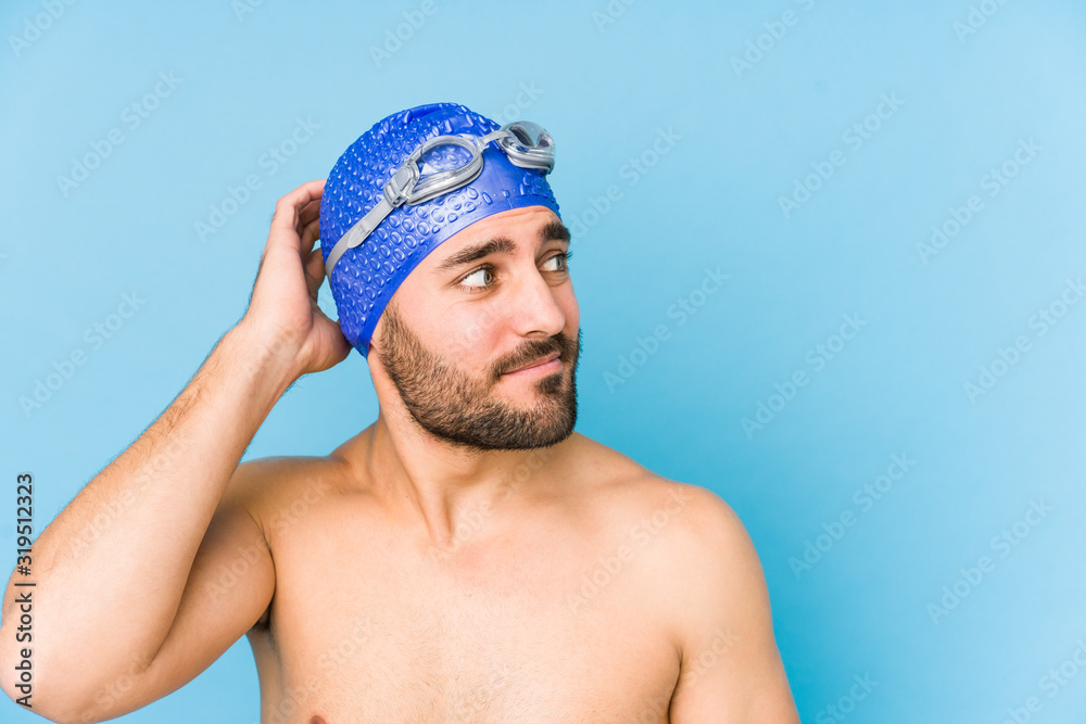 Young handsome swimmer man isolated touching back of head, thinking and making a choice.