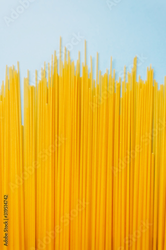 Wheat pasta spaghetti isolated on a blue background. top view