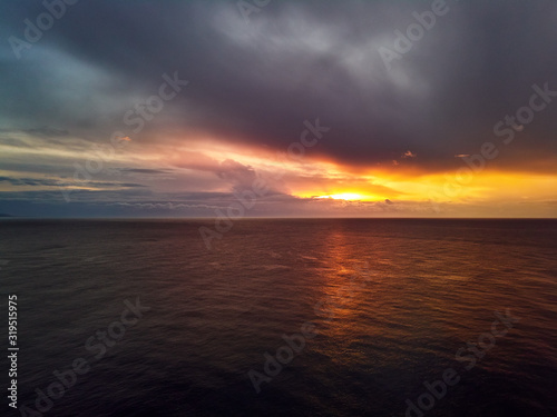 Bright colourful sunset with gloomy cloudy sky over Mediterranean Sea calm smooth waters. Spain  Costa Blanca