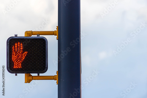 A black light pole with a pedestrian crossing light attached.