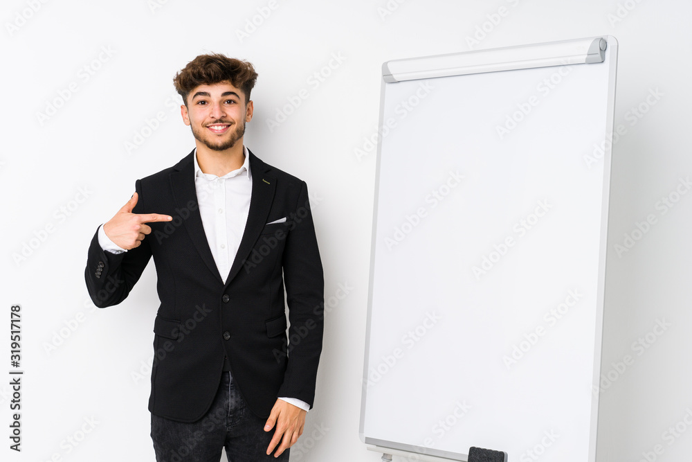 Young business coaching arabian man person pointing by hand to a shirt copy space, proud and confident