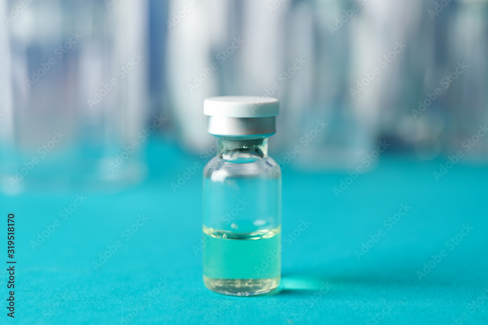 Bottle of vaccine on blue background, space for text. Virus protection. Healthcare and medical concept Bottle of vaccine on blue background, space for text. Virus protection. Healthcare and medical concept