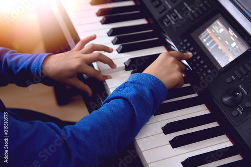 The hands of a child playing the piano