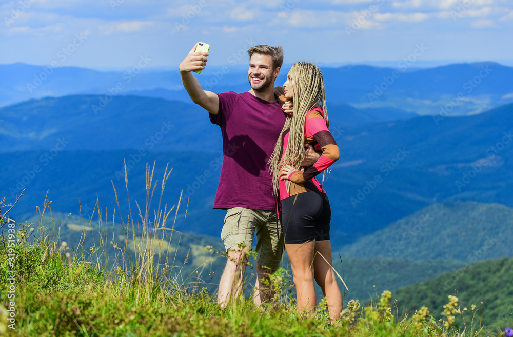 Couple taking photo. Couple in love hiking mountains. Lets take photo. Capturing beauty. Man and woman posing mobile photo. Summer vacation concept. Young adventurers. Travel together with darling