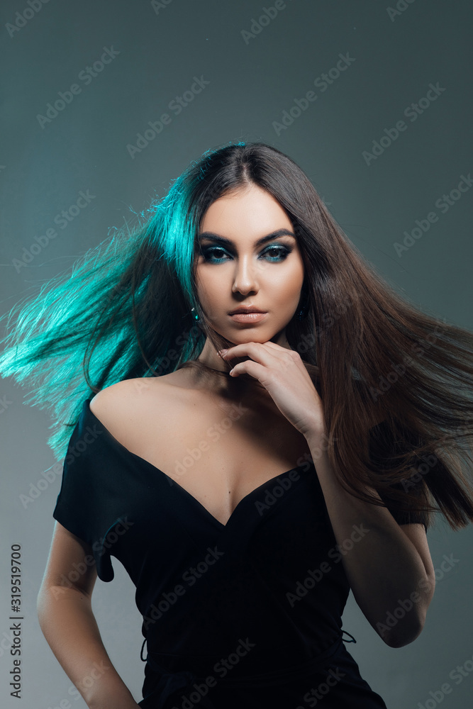 Naklejka premium Beautiful sexy woman with long brown hair. Pretty model poses at studio. Fashion Model Girl Portrait with Long Blowing Hair. Glamour Beautiful Woman with Healthy and Beauty Brown Hair