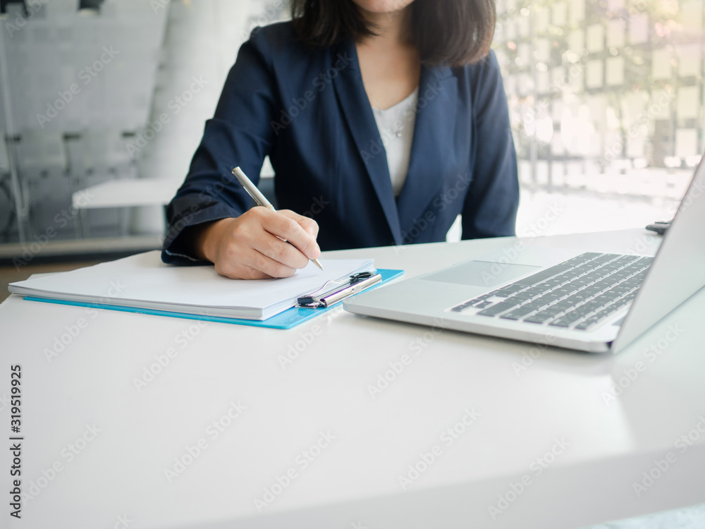 Business woman working at a computer, writing a note in chart. Finance and accounting concept. Business woman working at a computer, writing a note in chart. Finance and accounting concept.