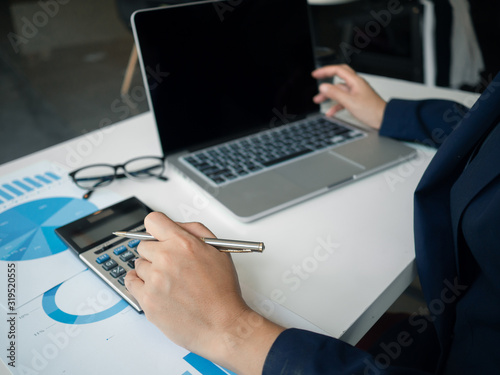 Wallpaper Mural Business woman hand working at a computer, using calculator and laptop to calculate an account. Finance and accounting concept. Torontodigital.ca