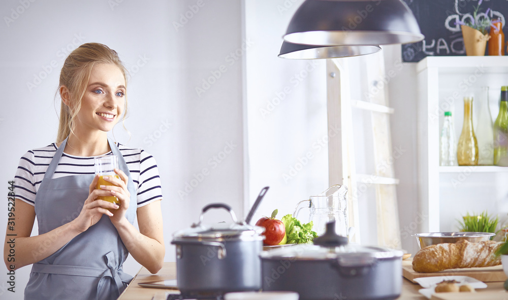The girl at the table in the kitchen with a glass of orange jui