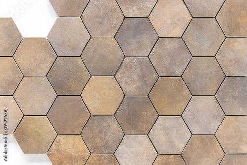 Beige-and-brown ceramic tile in the form of honeycombs. Hexagonal floor tiles.