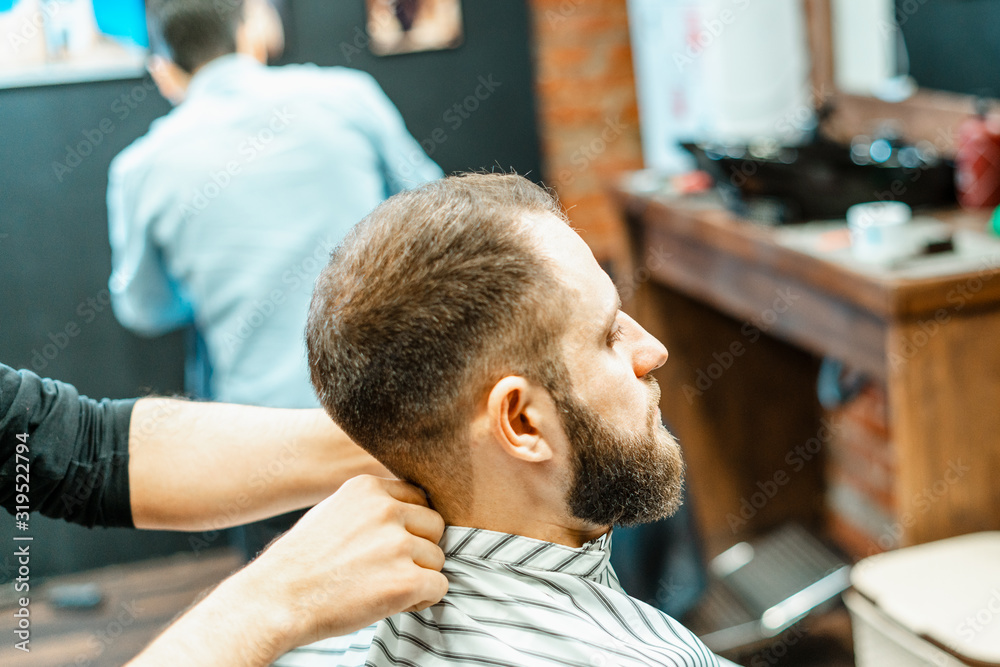Haircut at the hairdresser. Barber cuts the hair on the client's head. The process of creating hairstyles for men. A man in a barbershop. The near plan. Equipment stylist. Selective focus Haircut at the hairdresser. Barber cuts the hair on the client's head. The process of creating hairstyles for men. A man in a barbershop. The near plan. Equipment stylist. Selective focus