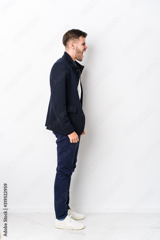 Full body young caucasian man isolated shouting towards a copy space Full body young caucasian man isolated shouting towards a copy space