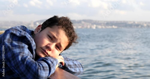 Portrait Of A Handsome Sad Teenage Boy Looking To Camera At The Seaside