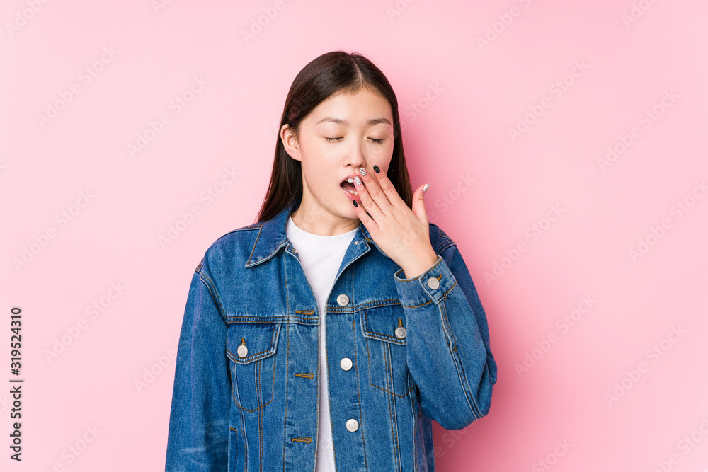 Young chinese woman posing in a pink background isolated yawning showing a tired gesture covering mouth with hand. Young chinese woman posing in a pink background isolated yawning showing a tired gesture covering mouth with hand.