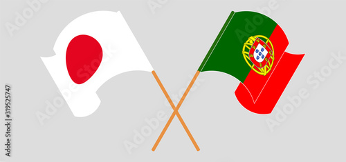 Crossed and waving flags of Portugal and Japan