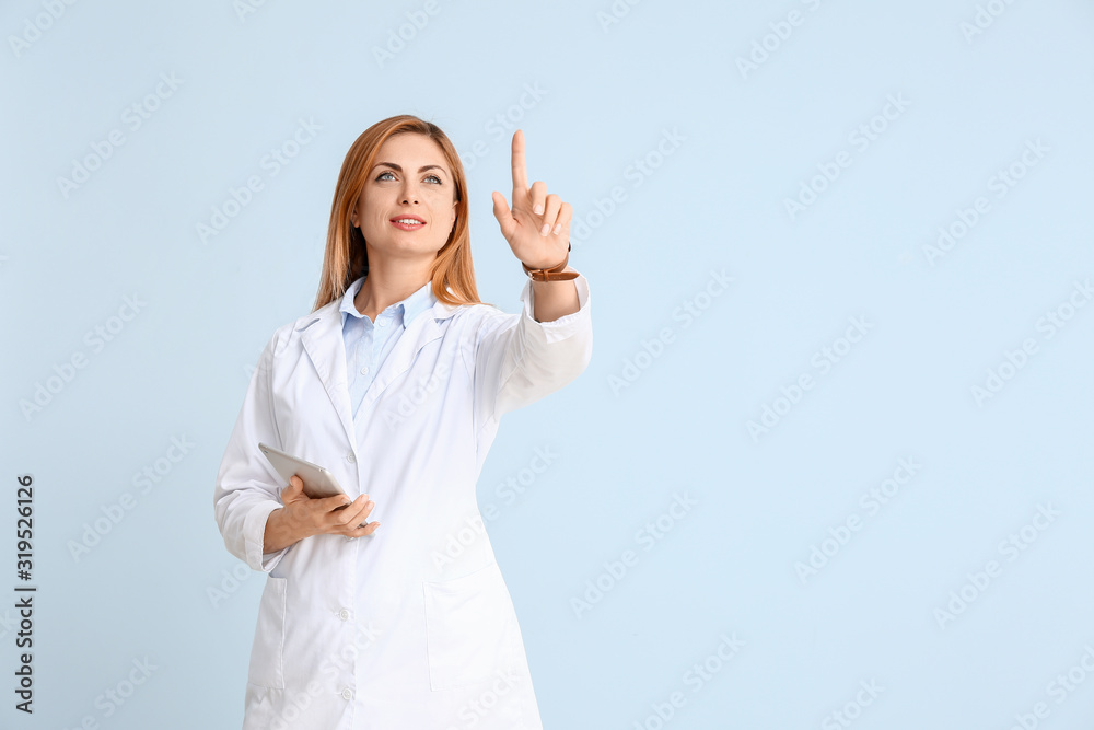 Portrait of female doctor with tablet computer showing something on color background Portrait of female doctor with tablet computer showing something on color background