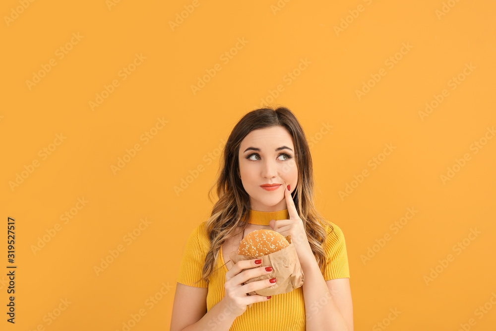 Portrait of thoughtful young woman with burger on color background Portrait of thoughtful young woman with burger on color background
