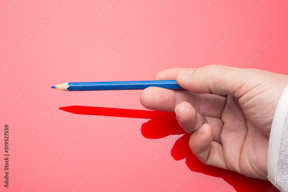 Colored pencil in the hand of an adult person Colored pencil in the hand of an adult person