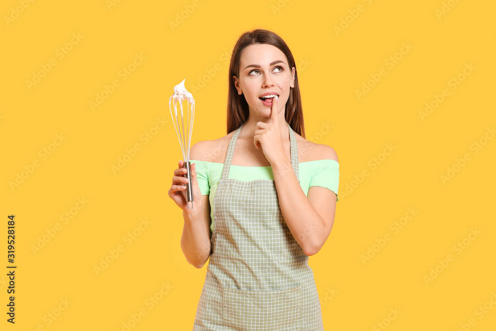 Thoughtful young housewife with whisk on color background Thoughtful young housewife with whisk on color background