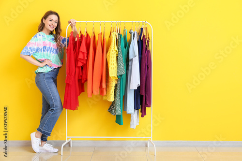Female stylist near rack with modern clothes