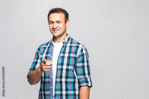 Portrait of a handsome young man pointing forward isolated on white background