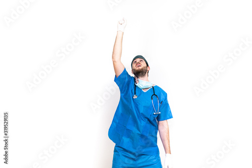 Medico ha successo durante un'operazione chirurgica ed esulta con un pugno in aria. Camice blu e sfondo bianco. photo