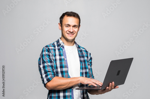 Happy young man with laptop isolated on white background