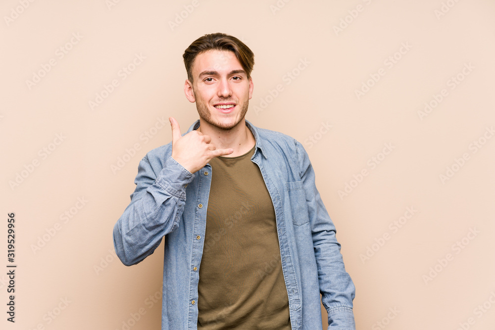 Young caucasian man posing isolated showing a mobile phone call gesture with fingers. Young caucasian man posing isolated showing a mobile phone call gesture with fingers.