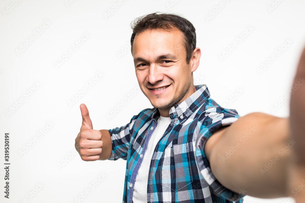 Happy man making selfie and showing thumb up isolated on white background Happy man making selfie and showing thumb up isolated on white background