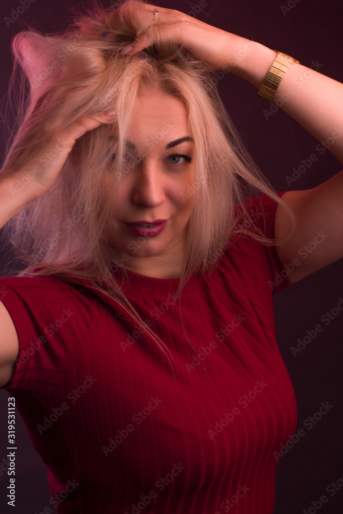 Full plus size high fashion xxl woman posing in Studio, In a red dress on a maroon background Full plus size high fashion xxl woman posing in Studio, In a red dress on a maroon background