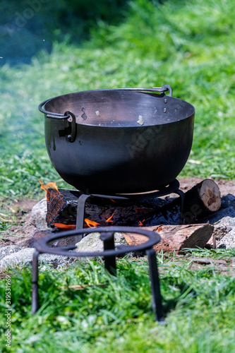 Kitchen of a rural camp, with pot on top of a bonfire