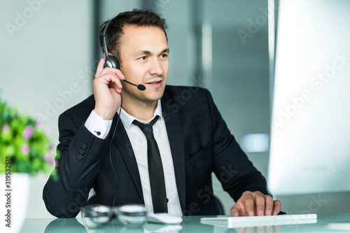 Businessman talking on the pc with headset in the office photo