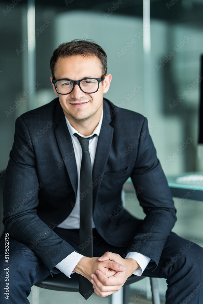 Portrait of young businessman in modern office. looking camera