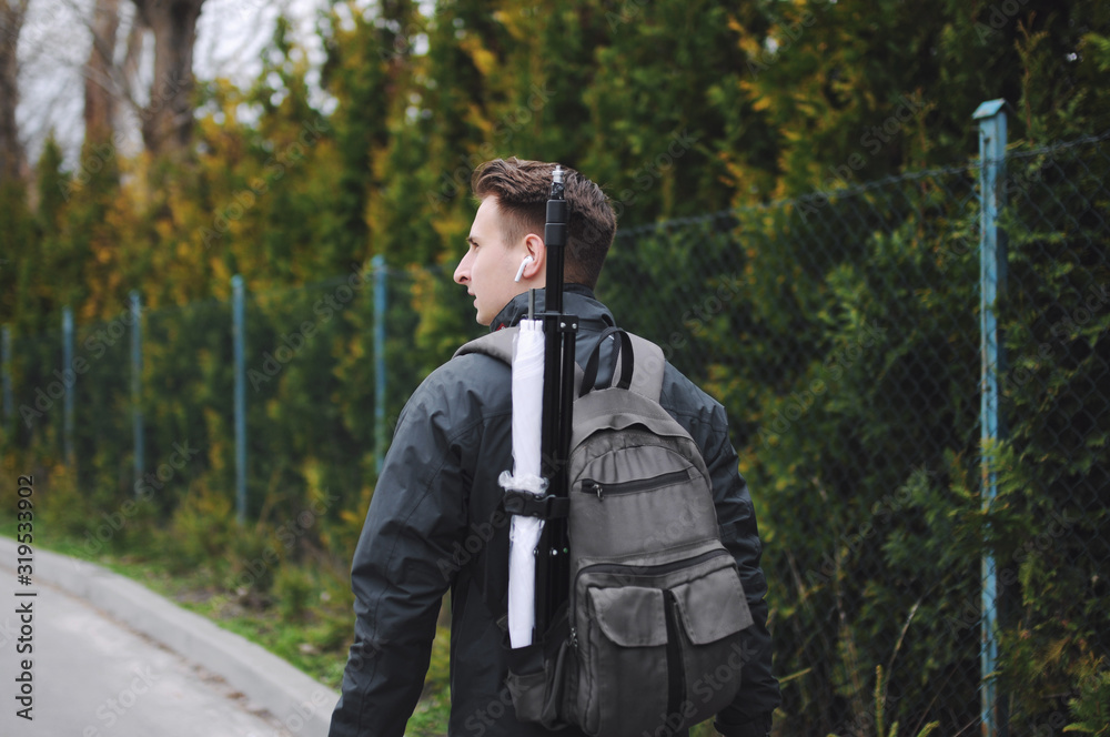 Back view of young attractive photographer wearing casual clothes