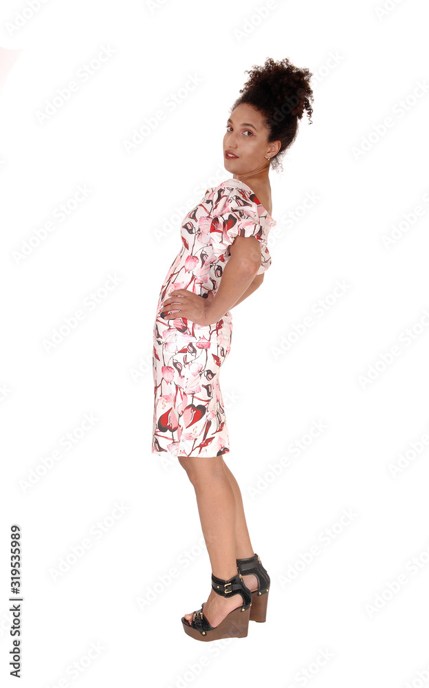 Beautiful woman standing in profile in a dress bending backwards Beautiful woman standing in profile in a dress bending backwards