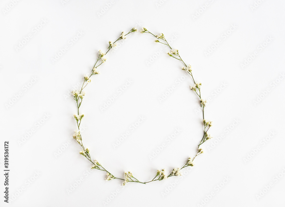Easter creative composition. Flat lay with shape of easter egg, frame of flowers on white background. Minimal spring concept. Copy space Easter creative composition. Flat lay with shape of easter egg, frame of flowers on white background. Minimal spring concept. Copy space