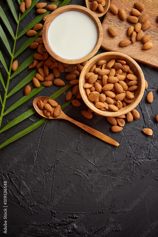 Close up of Almonds in wooden bowl and almond milk Close up of Almonds in wooden bowl and almond milk