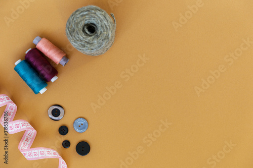 Group of sewing objects lying flat on a colorful background. Horizontal background for ad or packaging.