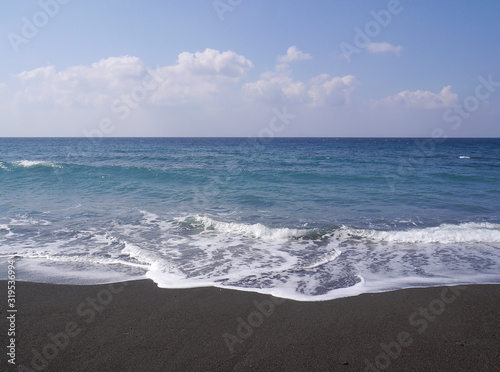 Seascape on the island of Santorini  Greece. Sea waves with foam on a sunny day.