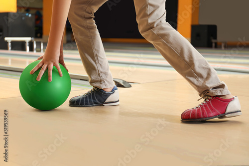Little boy throwing ball in bowling club, closeup