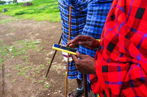 African man in traditional dress holding a cellphone. photo